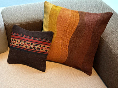 異なるサイズのクッションとソファの上に置かれた草木染めパッチワークキリムクッション（C-15119）の写真