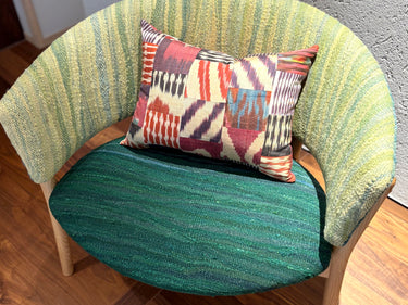 チェアの上に置かれたイカットパッチワークシルククッション(mc-0701)の写真1