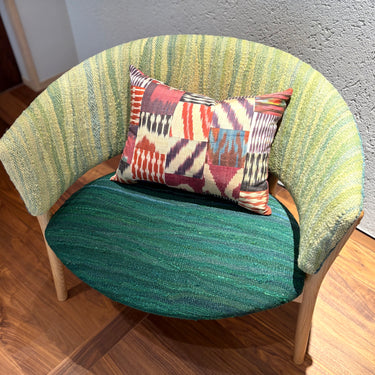 チェアの上に置かれたイカットパッチワークシルククッション(mc-0701)の写真1