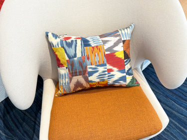 チェアの上に置かれたイカットパッチワーク シルククッション(MC-0705)の写真1