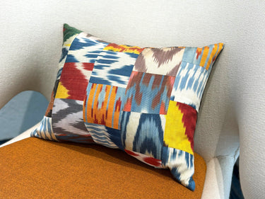 チェアの上に置かれたイカットパッチワーク シルククッション(MC-0705)の写真1