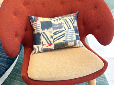 チェアの上に置かれたイカットパッチワークシルククッション(MC-0707)の写真1