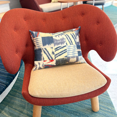 チェアの上に置かれたイカットパッチワークシルククッション(MC-0707)の写真1