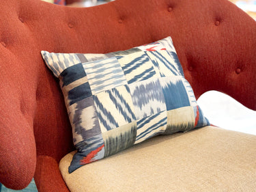 チェアの上に置かれたイカットパッチワークシルククッション(MC-0707)の写真1