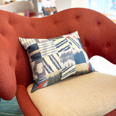 チェアの上に置かれたイカットパッチワークシルククッション(MC-0707)の写真1